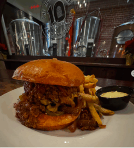 monks cellar burger texas chili, pickled jalapenos, cheddar cheese and grilled onions and a brioche bun