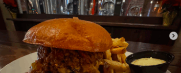 monks cellar burger texas chili, pickled jalapenos, cheddar cheese and grilled onions and a brioche bun