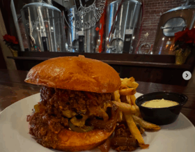 monks cellar burger texas chili, pickled jalapenos, cheddar cheese and grilled onions and a brioche bun